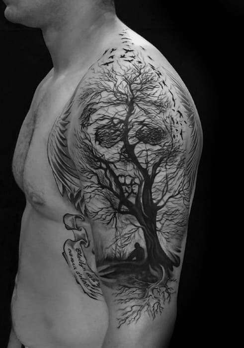 Detailed tree and skull tattoo with a man sitting beneath the branches, forming a haunting face with birds and angel wings above.
