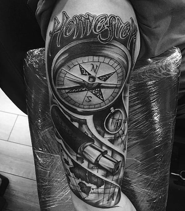 Tattoo of a compass, map, telescope, and quote on an arm