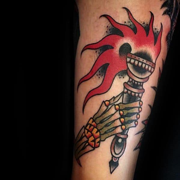 Torch tattoo gripped by a skeletal hand, with vivid red flames and bold black shading for a dramatic, traditional look.