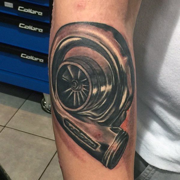 Realistic turbocharger tattoo on the forearm with detailed shading and metallic effects, symbolizing speed, power, and a passion for automotive performance.