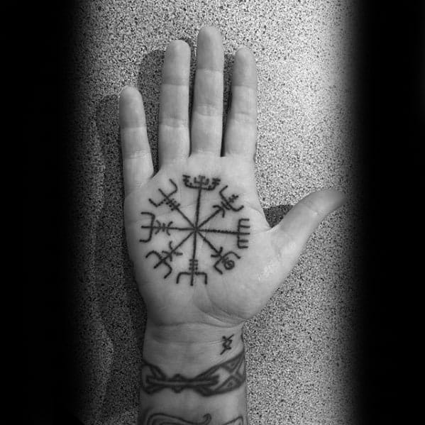 Vegvísir tattoo on the palm, a Nordic compass symbol believed to provide guidance and protection in travel and life’s journey.