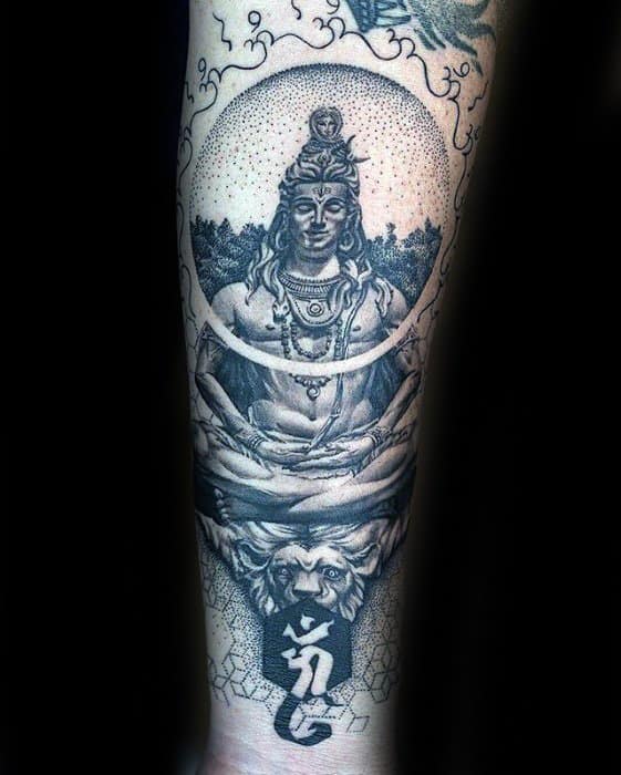 Forearm tattoo of Lord Shiva meditating with a calm expression, cosmic detailing, seated above a roaring lion and sacred symbol at the base.