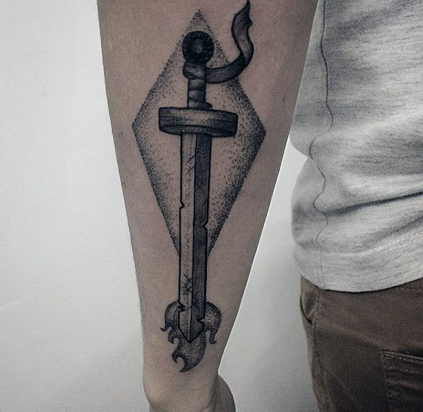Black ink Adventure Time tattoo of Finn’s Demon Blood Sword with shading and geometric background on the inner forearm.