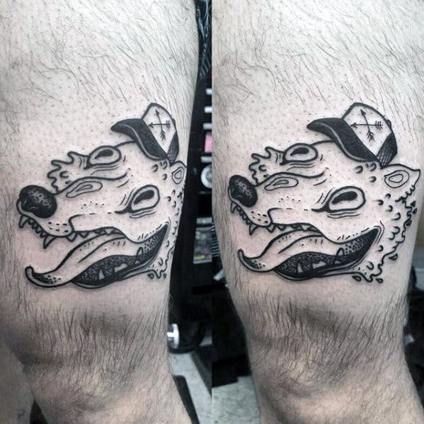 Black ink Adventure Time tattoo of the wolf-headed creature from the "Food Chain" episode, wearing a cap, inked on the thigh.