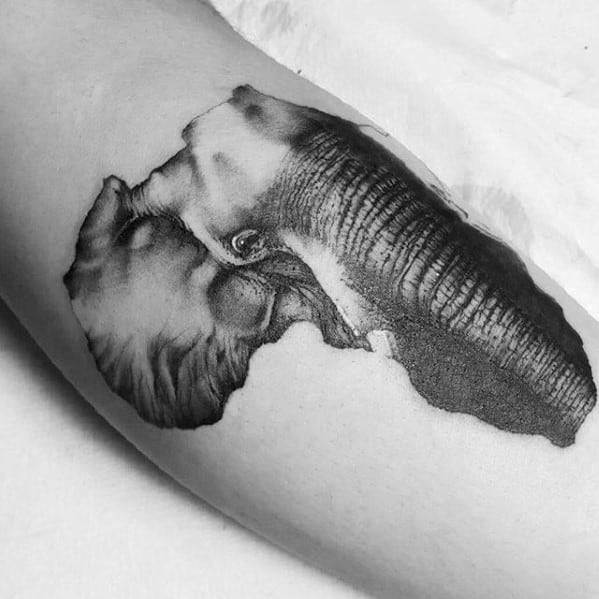 Black and white tattoo of an elephant and Africa outline on inner arm