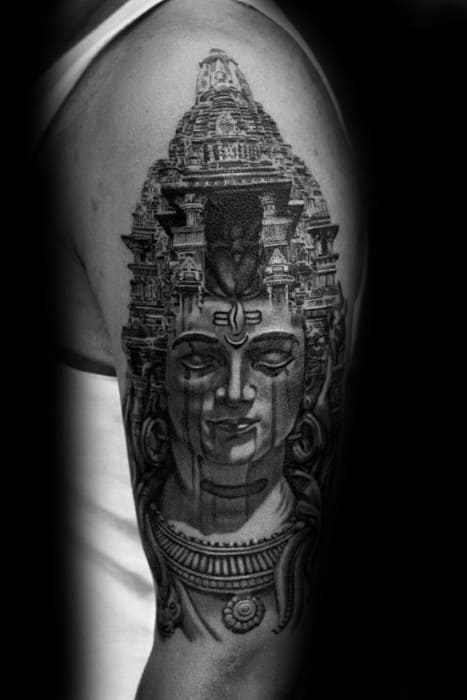 Lord Shiva tattoo with a detailed temple structure emerging from his head, combining divine face and architecture into a striking arm design.
