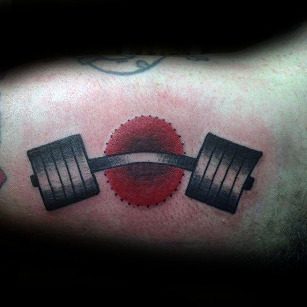 Heavy barbell tattoo with a bold red circle background, symbolizing raw power, intensity, and dedication to lifting.