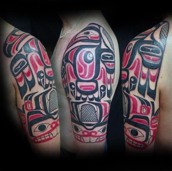 Bold half-sleeve beaver tattoo in Indigenous art style with red, black, and white geometric patterns and traditional symbolism.