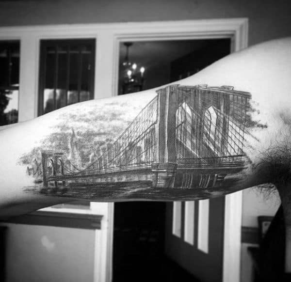 Guys Bicep Bridge Skyline With City Buildings Tattoo