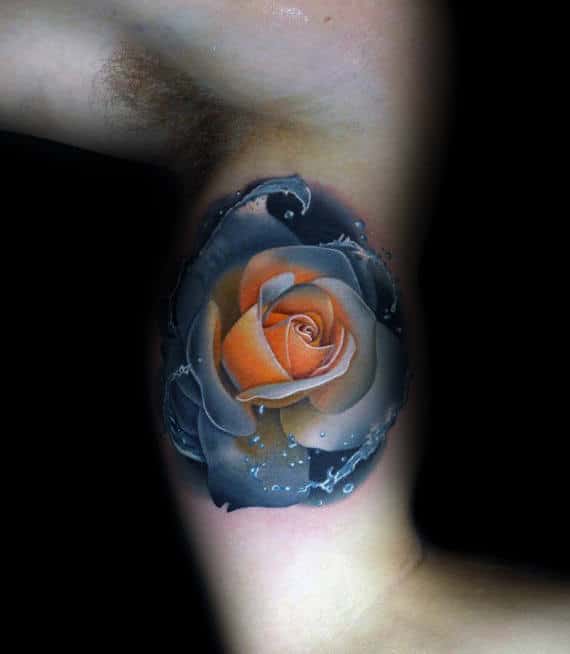 Tattoo of a realistic orange rose with black and blue shading on an inner arm