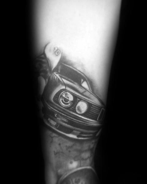 Realistic BMW E30 tattoo on forearm, featuring bold shading and motion effects for a dynamic and aggressive automotive design.
