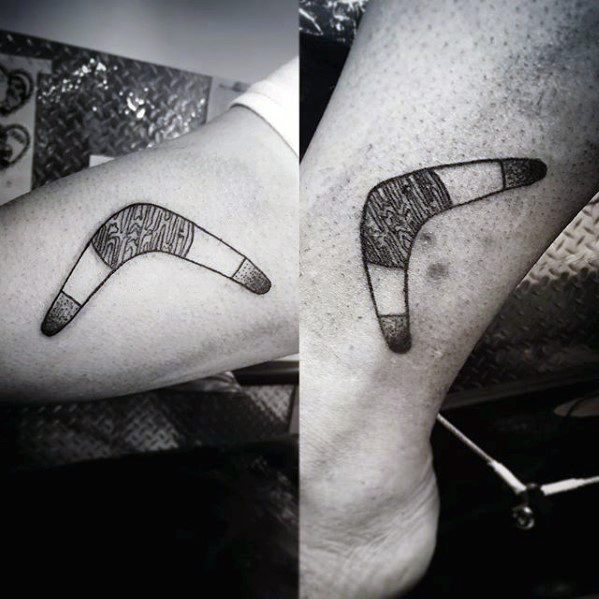 Matching boomerang tattoos with shaded segments and subtle linework, placed on the inner calf and ankle of two individuals.