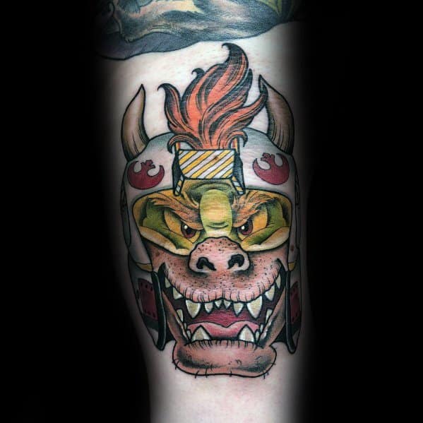 Unique Bowser tattoo on a man's leg featuring a fierce expression and a custom samurai-inspired helmet with bold colors and intricate details.