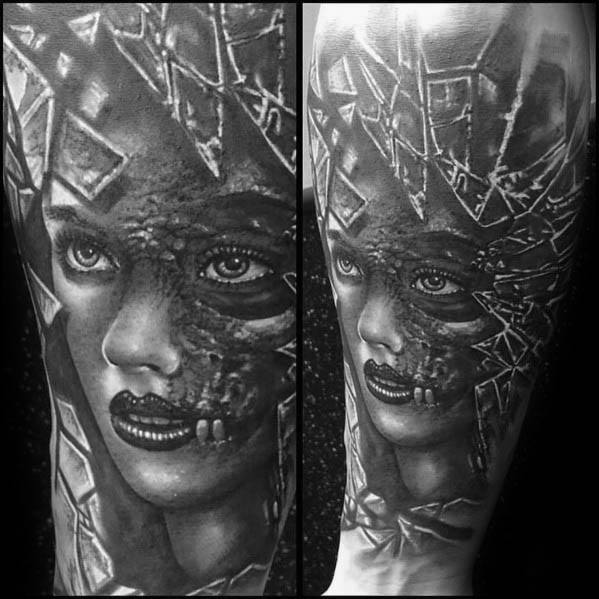 Realistic black and grey tattoo of a woman's face with cracked glass and exposed skeletal features, blending beauty with a haunting decay.