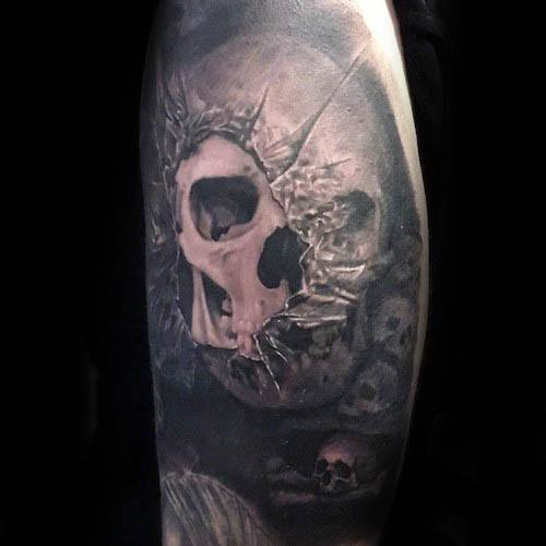 Dark and dramatic tattoo of a cracked skull breaking through glass, surrounded by shadows and smaller skulls for a haunting effect.