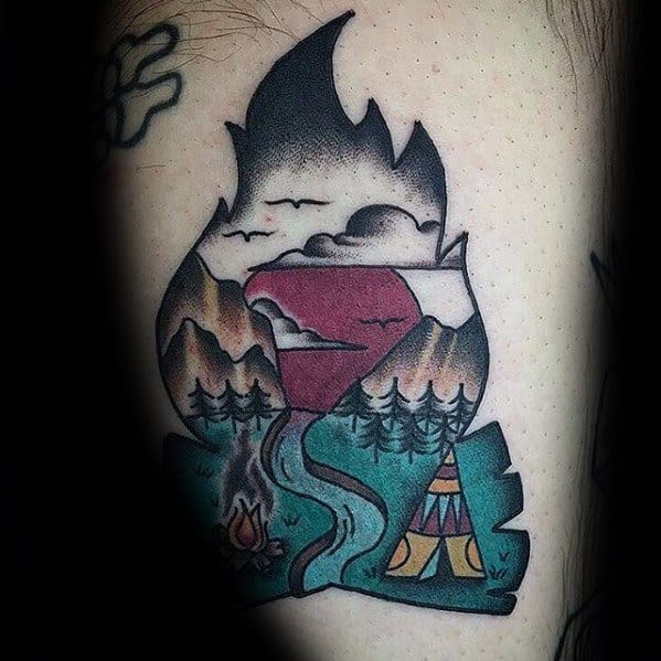 Creative campfire tattoo shaped like a flame, featuring mountains, river, trees, sunset sky, and a small tent and fire scene below.