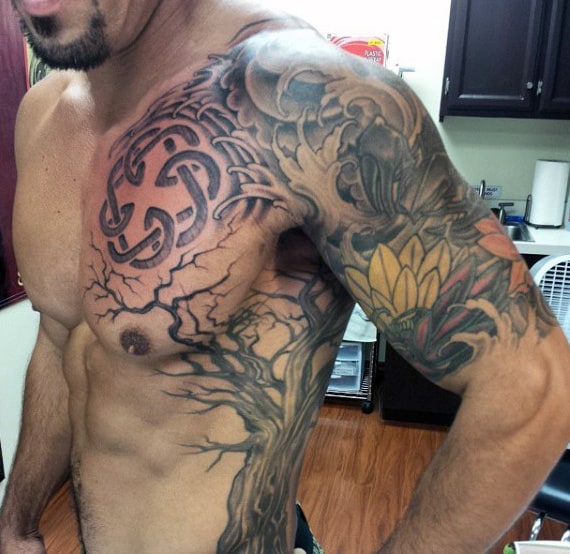 Shirtless man with intricate chest, arm, and shoulder tattoo
