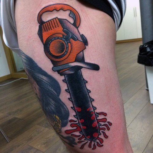 Bold orange and black chainsaw tattoo with a blood-covered blade and splatter at the tip, blending cartoon and horror styles.