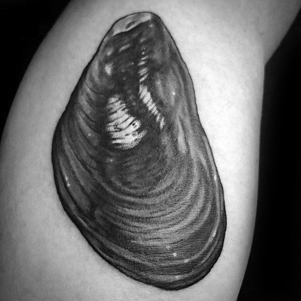 Detailed black and grey mussel shell tattoo on the arm with fine linework and soft shading to create a lifelike texture.
