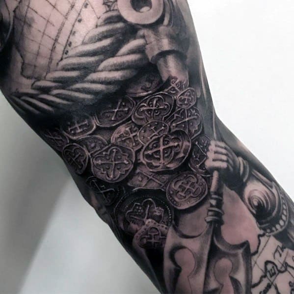 Intricate sleeve tattoo featuring a pile of ancient coins, ropes, and weaponry, creating a detailed and treasure-inspired design.