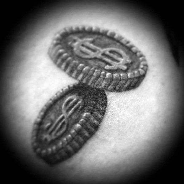 Realistic tattoo of two stacked oval coins with dollar signs, featuring intricate shading for a three-dimensional effect.