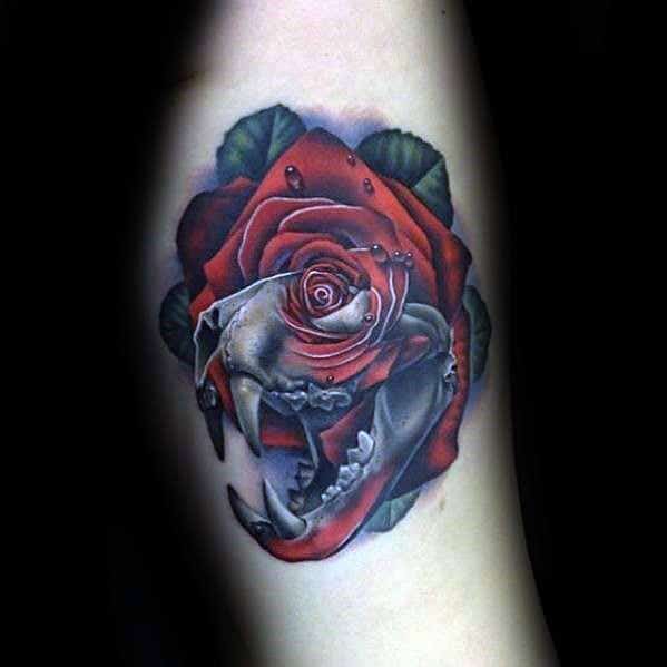 Tattoo of a red rose with a detailed animal skull in the center, adorned with dew drops