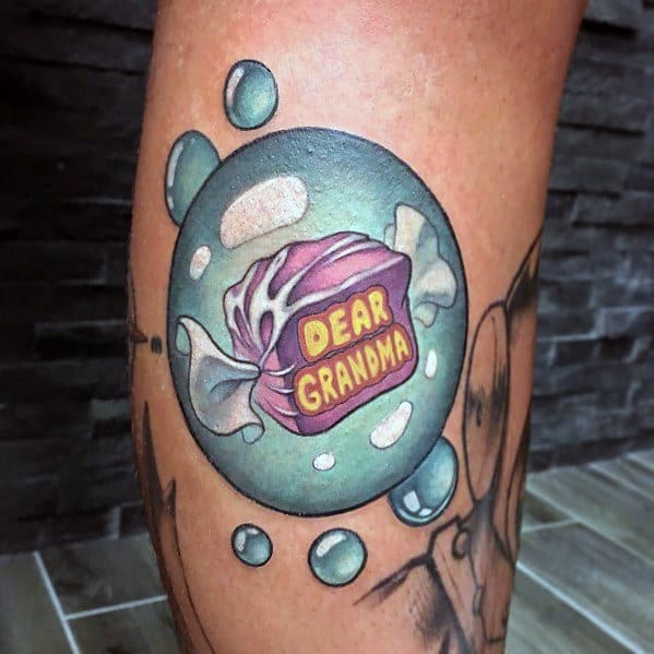 Whimsical tattoo of a nostalgic hard candy labeled "Dear Grandma," encased in a floating bubble with soft highlights and shading.