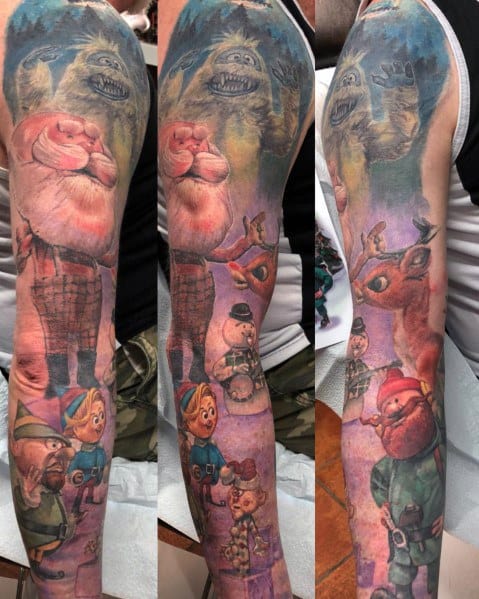 Christmas-themed full sleeve tattoo featuring characters from *Rudolph the Red-Nosed Reindeer*, including Yukon Cornelius, Hermey, Bumble, and Rudolph.