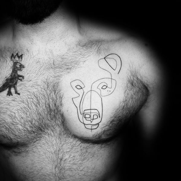 Abstract continuous line tattoo of a stylized face on the chest, featuring fluid black ink strokes for a modern and artistic design.
