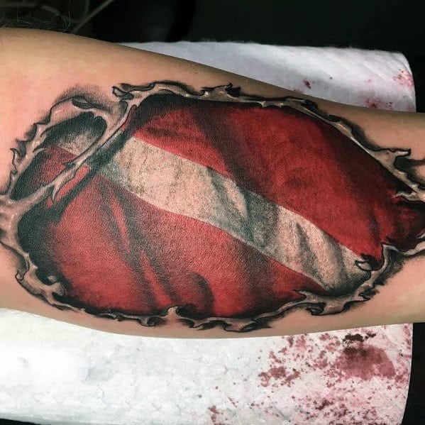 Tattoo of torn skin revealing a red and white dive flag underneath, symbolizing an unshakable passion for scuba diving and ocean exploration.