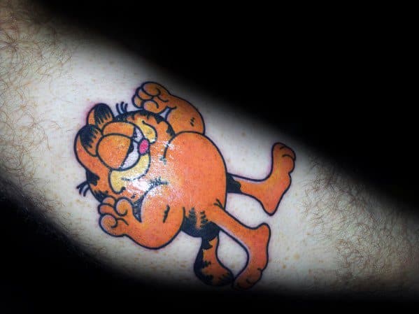 Garfield tattoo in a relaxed, belly-up pose with a cheeky grin—fun and carefree design for classic cartoon lovers.