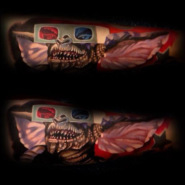 Realistic Gremlin tattoo with 3D glasses, sharp teeth, and a dark, cinematic vibe, blending horror and nostalgia.