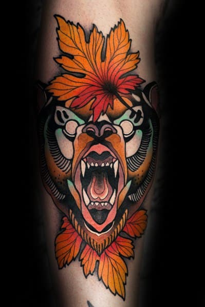 Neo-traditional bear tattoo with a fierce roaring expression, bold black outlines, and vibrant autumn leaves in shades of orange and red.