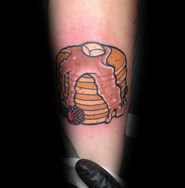 Classic pancake tattoo with syrup, butter, and berries, featuring bold outlines and a traditional style for a fun and delicious design.