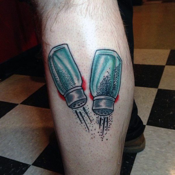 Tattoo of two tilted salt and pepper shakers spilling seasoning, with bold shading and red highlights for a dynamic and playful design.