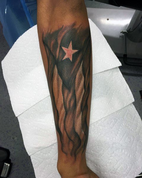 Puerto Rican flag tattoo on the forearm with a bold, smoky effect and a red star, creating a striking and artistic design.