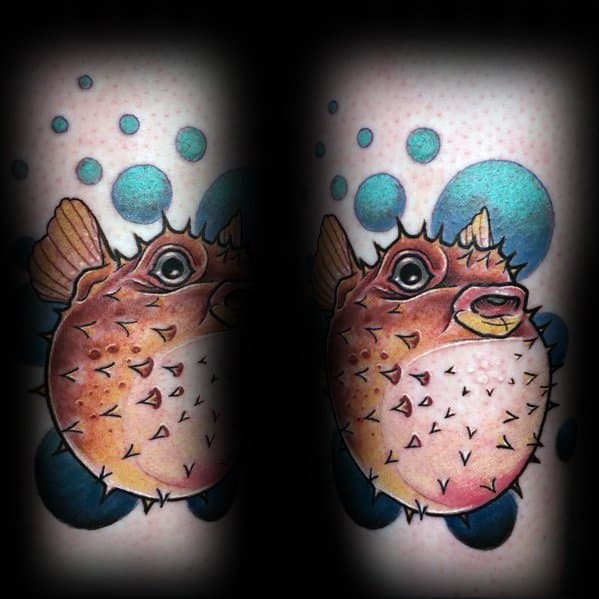 Vibrant pufferfish tattoo with detailed shading, surrounded by blue bubbles, creating a dynamic underwater effect on the skin.