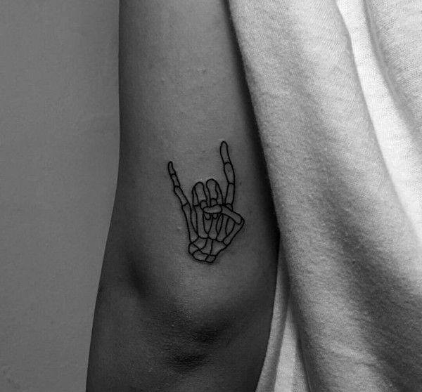 minimalist black line tattoo of a skeleton hand making the "I love you" sign in American Sign Language, placed on the upper arm
