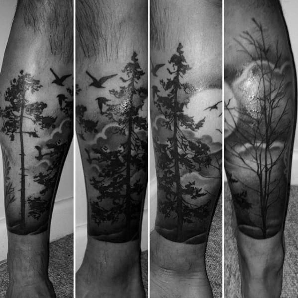 Black ink forest tattoo on the leg, featuring tall trees, flying birds, detailed clouds, and a glowing moon for a mystical nature-inspired design.