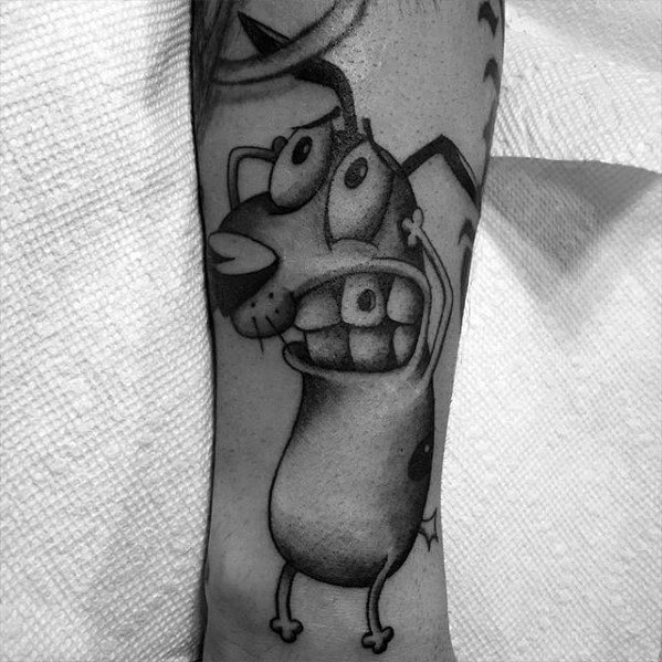 Black and grey tattoo of Courage the Cowardly Dog with a frightened expression, wide eyes, and detailed shading on the lower leg.