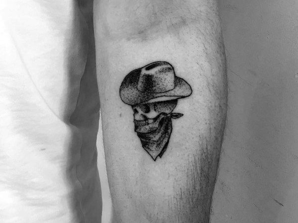 Small black and gray tattoo of a cowboy skull wearing a hat and bandana, done in a fine dotwork style for a rugged Western look.