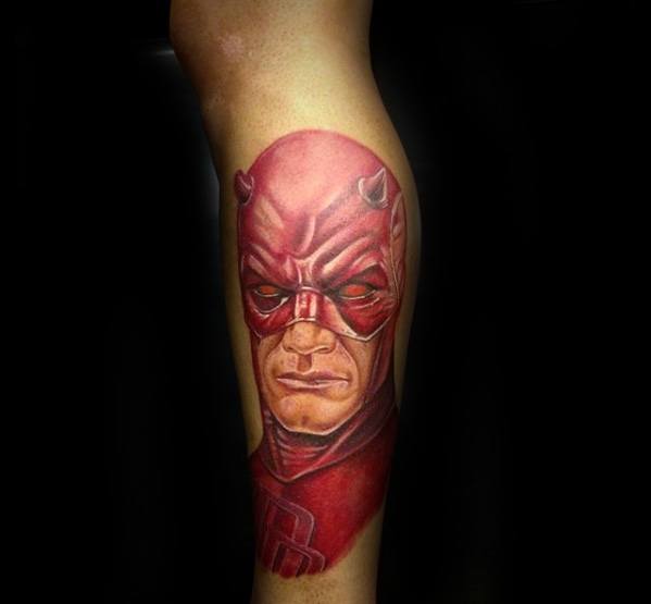 Detailed Daredevil tattoo with sharp red tones and a focused expression, capturing the character’s strength and determination.