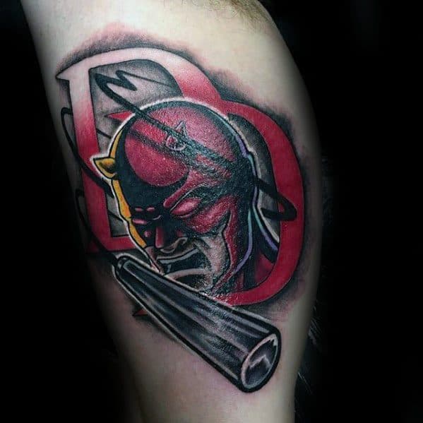 Bold Daredevil tattoo with stylized DD logo, dramatic shadows, and extended baton, blending comic and modern tattoo styles.