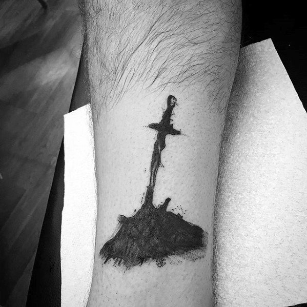 Minimalist black ink tattoo of the Dark Souls bonfire sword silhouette rising from a mound of ash and charred ground.