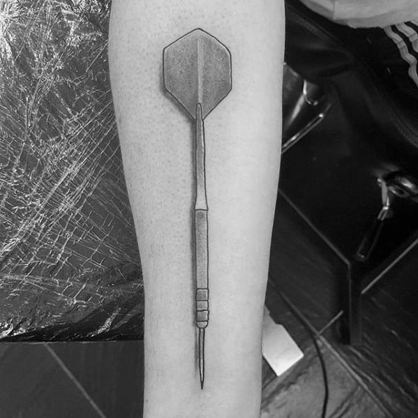 Minimalist black and grey forearm tattoo of a single dart, cleanly shaded to highlight precision and simplicity.