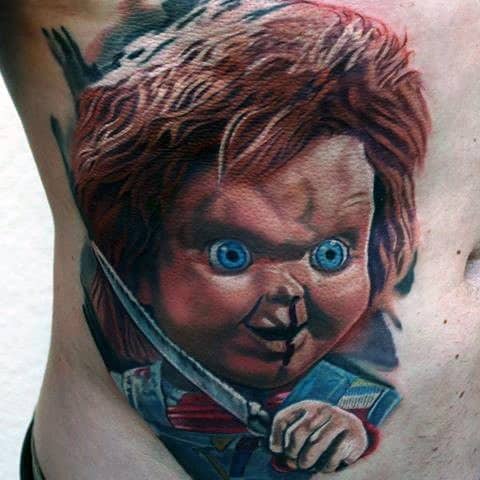 Realistic Chucky tattoo with piercing blue eyes, intense shading, and a sharp knife, creating a bold and menacing horror-inspired design.
