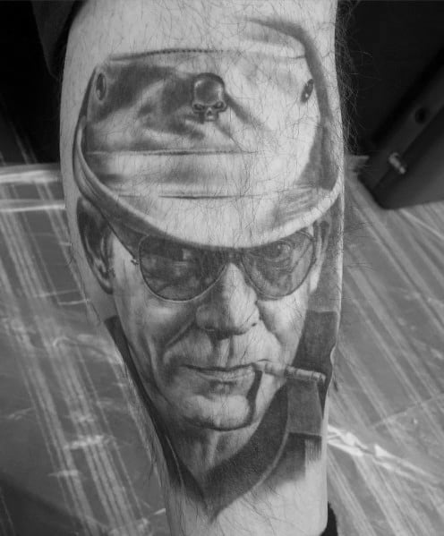 Black and white Hunter S. Thompson tattoo featuring a highly detailed portrait with aviator glasses, a military-style hat with a skull emblem, and a cigarette.