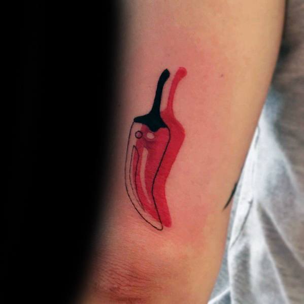 Minimalist red chili pepper tattoo with abstract shading and a bold black stem, creating a sleek and modern design on the arm.
