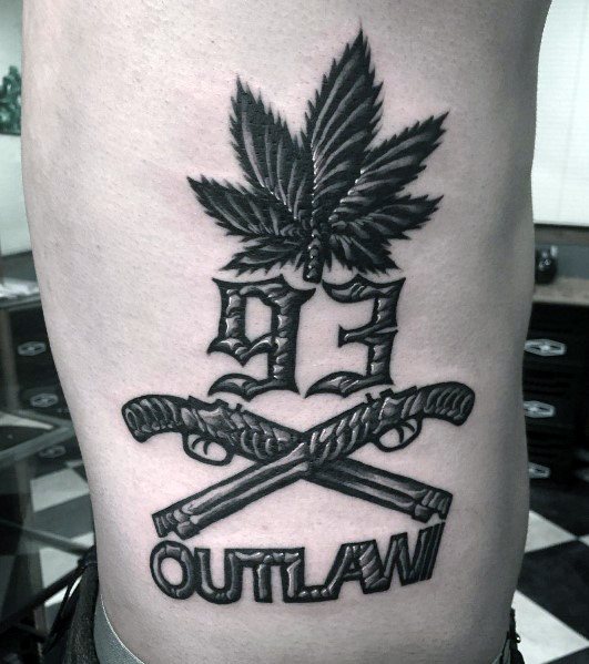 Black and grey outlaw-themed tattoo featuring crossed shotguns, a bold "93" design, a cannabis leaf, and the word "OUTLAW" in heavy lettering.