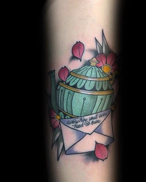 Color tattoo of Pam’s teapot gift to Jim from The Office, featuring an envelope with "everything you’ll ever need to know" written on it, surrounded by flowers.